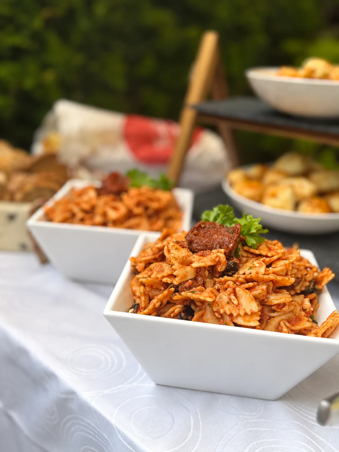 Nudelsalat mit Tomatensauce in karierten Schalen am Buffet